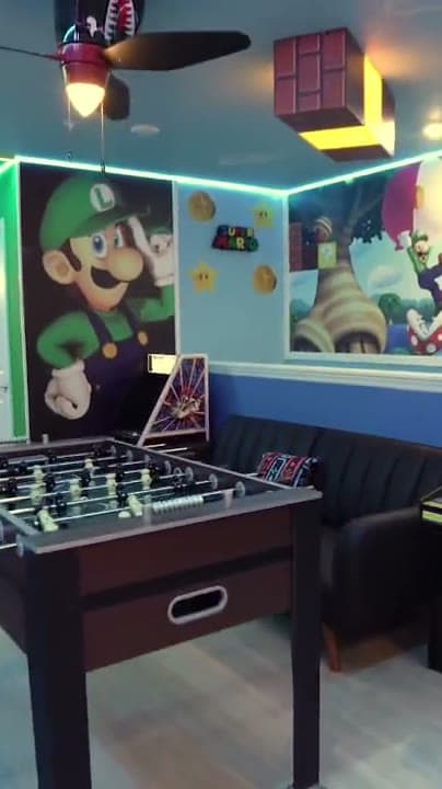 Game room with arcade machines and a foosball table inside a Dream Vacation Orlando themed home